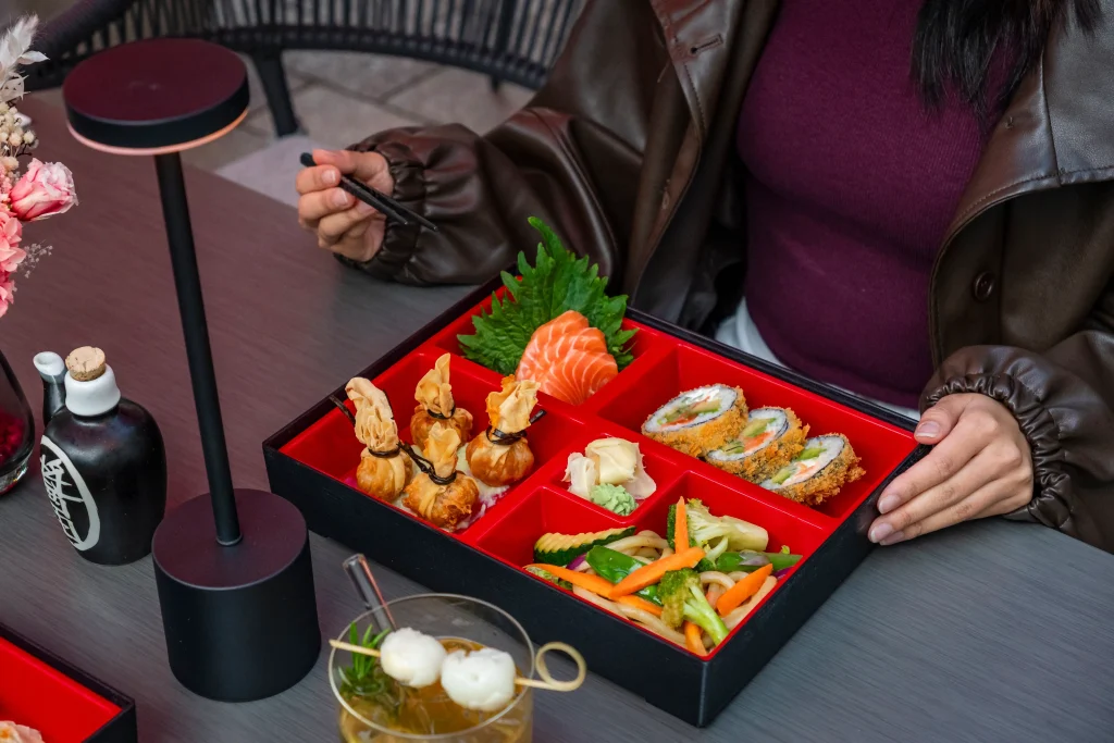 Nahaufnahme Bento-Box mit Sushi, Gyoza und frischen Beilagen bei Mai Garden Offenburg